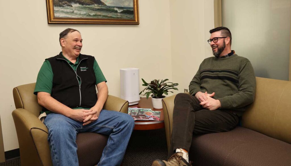 Paul Hudgik ’78, left, sits with his nephew Mark Hudgik ’02, HCC director of Admissions and Onboarding, during a recent visit to HCC.