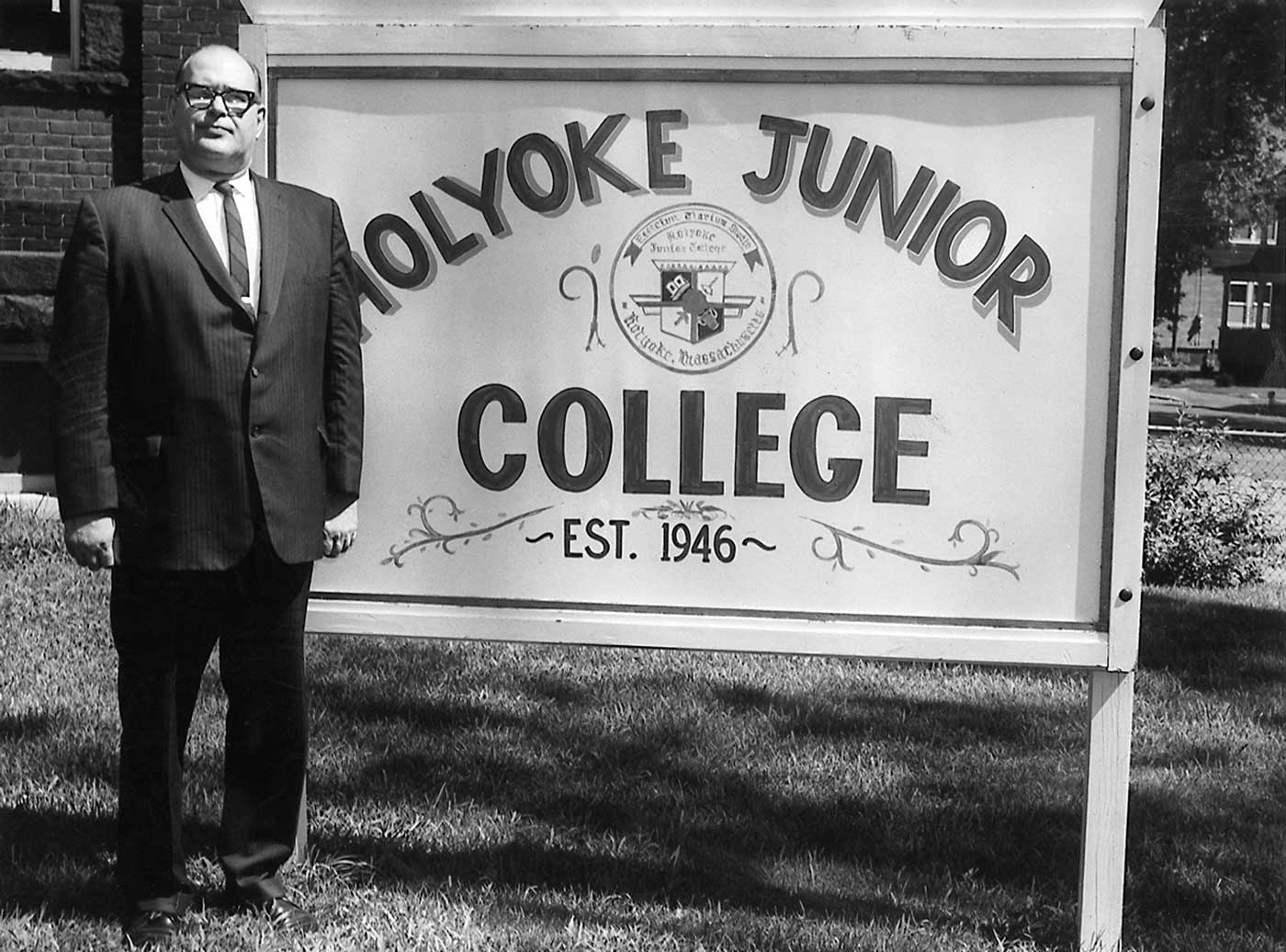 George Frost, the first president of Holyoke Community College, stands by the main college sign after the name was changed from Holyoke Graduate School to Holyoke Junior College in 1947