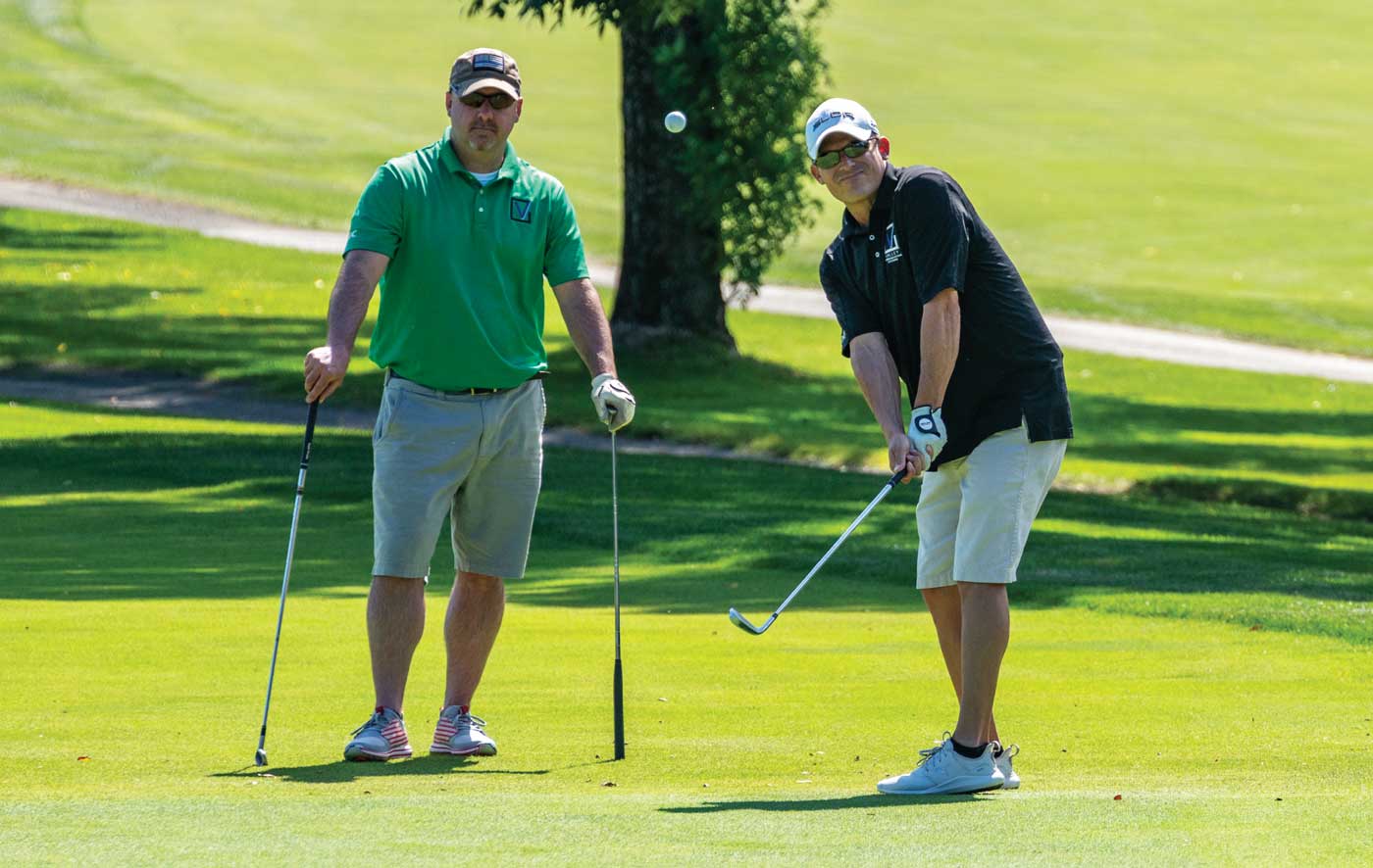 A golfer lobs a shot onto the green during the annual HCC tournament.