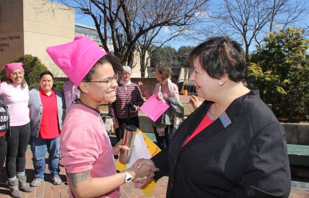 March 2017: President Royal greets student Kiana Estime in the HCC Courtyard after a celebration for International Women’s Day.