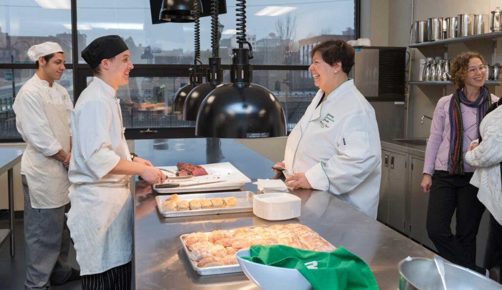 January 2018: President Royal dons a white chef’s coat during an open house at the new HCC MGM Culinary Arts Institute.