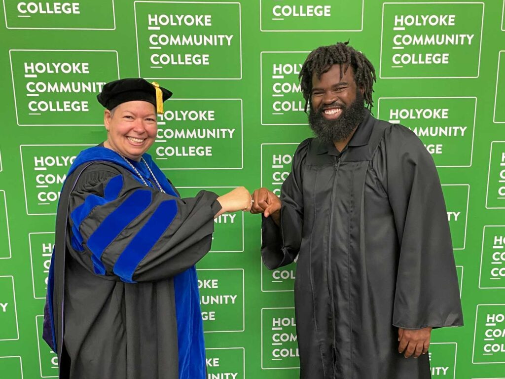 June 2022: President Royal bumps fists before Commencement with alum Mychal Connolly ’04, recipient of HCC’s 2022 Distinguished Service Award.