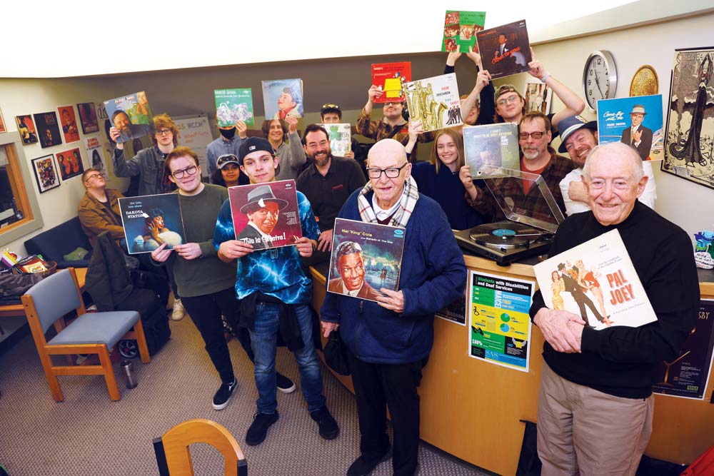George Counter ’57, far right, and his brother Joe, join members of the HCC radio club in the WCCH studio lobby after donating dozens of vintage vinyl records.