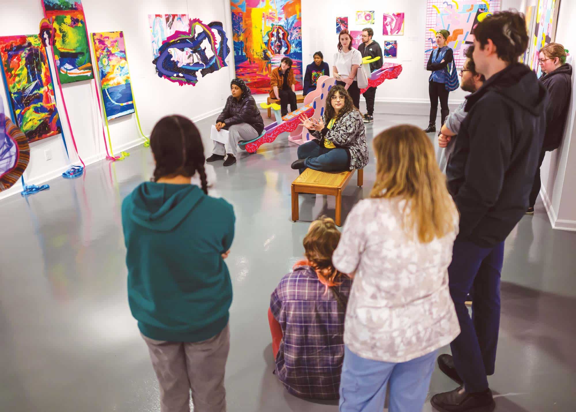 Director Rachel Rushing, seated, talks to a class of students during a gallery tour in November 2025.